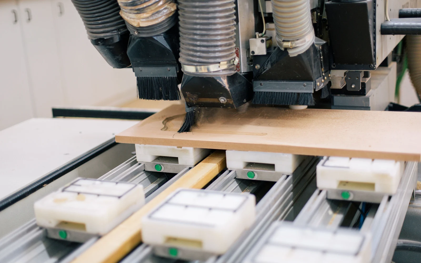 CNC woodworking equipment shaping a wooden panel
